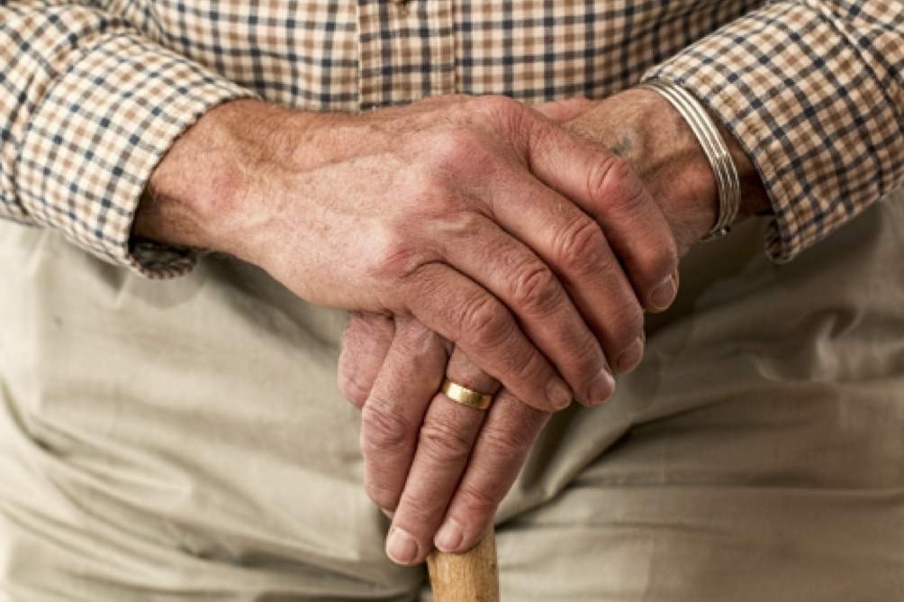 Immagine di un pensionato in cerca di un prestito. Si tiene le mani in cerca di una soluzione.